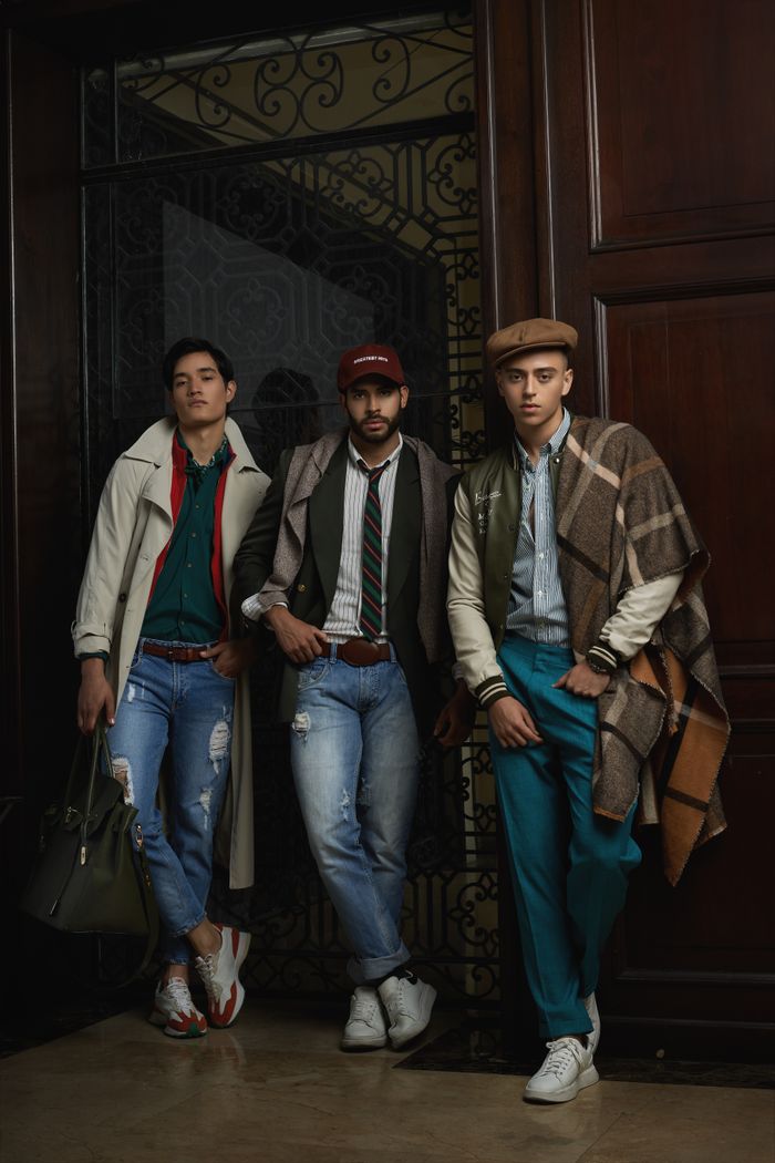 About Three stylish men pose indoors in trendy casual attire, highlighting modern fashion trends.
