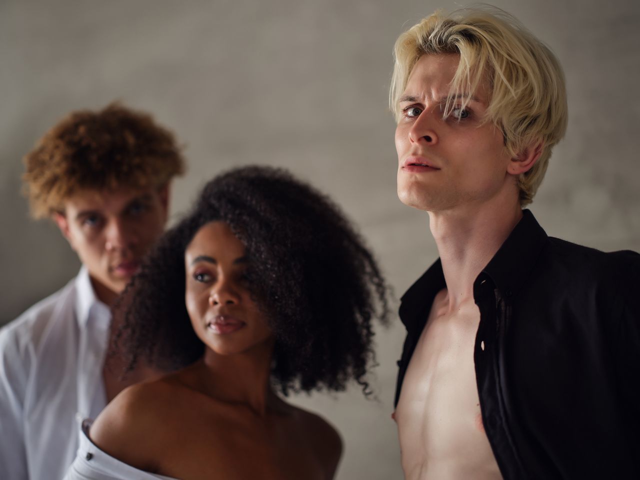 Contact Stylish portrait of diverse young adults in fashionable attire with a dramatic look.